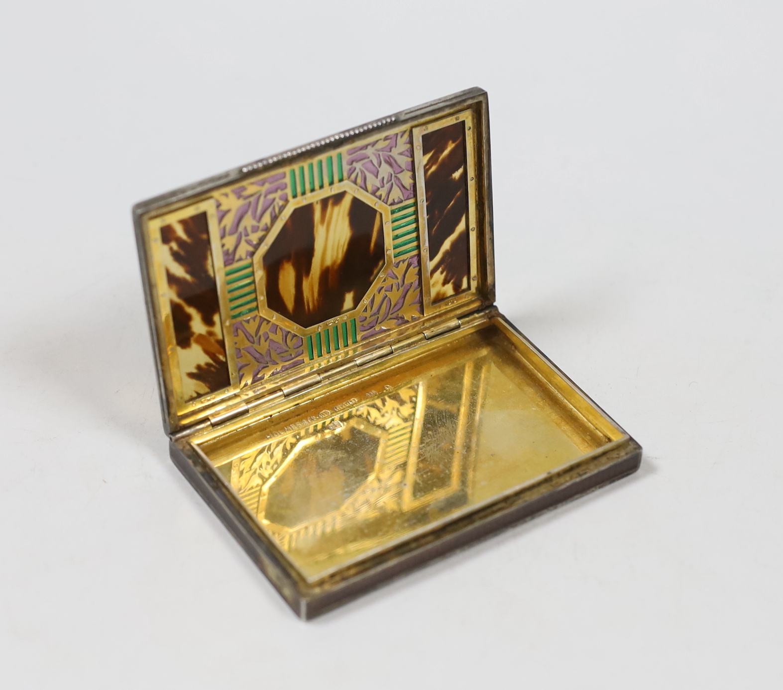 A 1920's Austrian 935S white metal, tortoiseshell, enamel and plique a jour cigarette case, import marks for London, 1927, 87mm, retailed by Holmes & Co?.